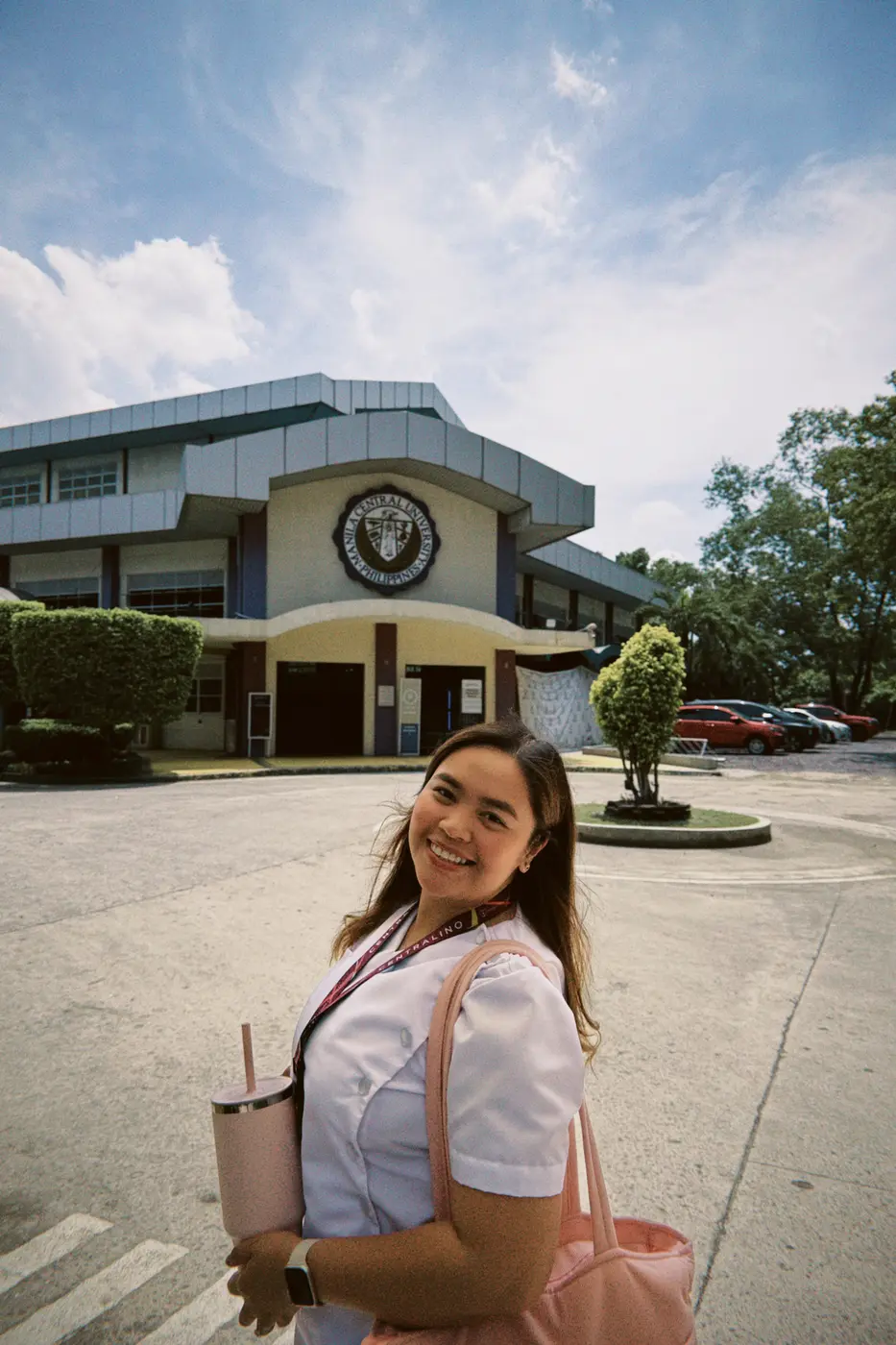 Janjae standing on campus in her nursing uniform